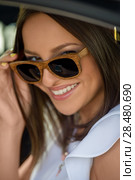 Young pretty girl wearing sunglasses listening music with headphones in car. Summer fun. Стоковое фото, фотограф Kirill Kedrinskiy / Ingram Publishing / Фотобанк Лори