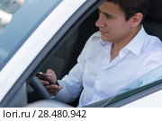 The young man behind the wheel driving car and calling phone. Стоковое фото, фотограф Kirill Kedrinskiy / Ingram Publishing / Фотобанк Лори
