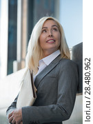 Image of pretty businesswoman looking away and holding documents outdoor. Стоковое фото, фотограф Kirill Kedrinskiy / Ingram Publishing / Фотобанк Лори