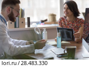 Confident practitioner consulting woman in hospital. Explaining results of chest x-ray scan. Стоковое фото, агентство Ingram Publishing / Фотобанк Лори