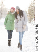 Two girls walk in the forest covered in snow. Стоковое фото, фотограф Kirill Kedrinskiy / Ingram Publishing / Фотобанк Лори