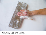 Plastering man hand with plaste and plaster spatula trowel in wall. Стоковое фото, фотограф Tono Balaguer / Ingram Publishing / Фотобанк Лори