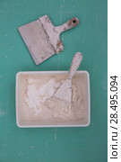Platering tools for plaster like plaste trowel spatula on green drywall plasterboard. Стоковое фото, фотограф Tono Balaguer / Ingram Publishing / Фотобанк Лори