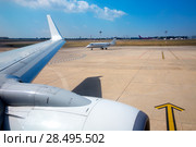 Airplane wing in airport with aircraft background with blue sky. Стоковое фото, фотограф Tono Balaguer / Ingram Publishing / Фотобанк Лори
