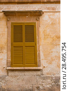 Ciutadella Menorca wooden shutter window on grunge yellow downtown wall at Balearic islands (2013 год). Стоковое фото, фотограф Tono Balaguer / Ingram Publishing / Фотобанк Лори