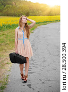 Alone young woman with violin case by country road. Country music concept. Стоковое фото, фотограф Olena Mykhaylova / Ingram Publishing / Фотобанк Лори