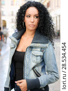 Portrait of a young black woman, afro hairstyle, wearing dening jacket in urban background. Стоковое фото, фотограф Javier Sánchez Mingorance / Ingram Publishing / Фотобанк Лори
