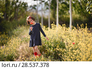 Little girl walking in nature field wearing beautiful dress with flowers in her hand. Стоковое фото, фотограф Javier Sánchez Mingorance / Ingram Publishing / Фотобанк Лори