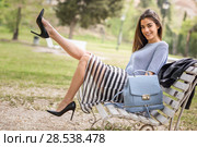 Portrait of young woman with beautiful legs in urban park wearing casual clothes. Girl wearing striped skirt, sweater and high heels. Стоковое фото, фотограф Javier Sánchez Mingorance / Ingram Publishing / Фотобанк Лори
