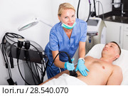 Female doctor is doing vacuum massage procedure for anti-fat to patient. Стоковое фото, фотограф Яков Филимонов / Фотобанк Лори