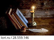 Старые книги, перо и догорающая свеча. Стоковое фото, фотограф Наталья Осипова / Фотобанк Лори