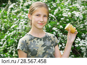Улыбающаяся девочка со стаканчиком мороженого в руке в летнем парке. Стоковое фото, фотограф Круглов Олег / Фотобанк Лори