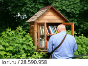Уличная библиотека для книголюбов. Город Таруса, библиотечный домик у входа в городской сквер (2018 год). Редакционное фото, фотограф Щеголева Ольга / Фотобанк Лори