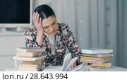 Tired woman with a lot of books. Стоковое видео, видеограф Илья Шаматура / Фотобанк Лори