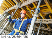 Builder installing or dismantling pole support for concrete monolithic formwork at housebuilding. Стоковое фото, фотограф Дмитрий Калиновский / Фотобанк Лори