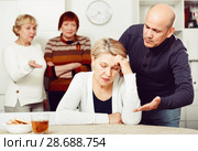 Mature female is sitting upset and man is apologizing. Стоковое фото, фотограф Яков Филимонов / Фотобанк Лори