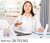 Practicioner girl in medical uniform is working with documents and laptop. Стоковое фото, фотограф Яков Филимонов / Фотобанк Лори
