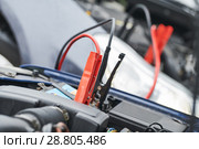 Automobile help. booster jumper cables charging automobile discharged battery. Стоковое фото, фотограф Дмитрий Калиновский / Фотобанк Лори