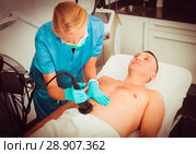 Female specialist is massaging with vacuum to belly of client for anti-fat. Стоковое фото, фотограф Яков Филимонов / Фотобанк Лори