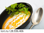 Recipe of pumpkin soup puree with ginger root - roast pumpkin in olive oil, beat in blender with vegetable broth. Add whisked cream with garlic and ginger. Serve with greens. Стоковое фото, фотограф Яков Филимонов / Фотобанк Лори