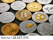 Set of different gold and silver coins of crypto-currencies on a dark background with bright light. Top view. Стоковое фото, фотограф Ярослав Данильченко / Фотобанк Лори