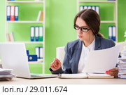 Young female employee very busy with ongoing paperwork. Стоковое фото, фотограф Elnur / Фотобанк Лори