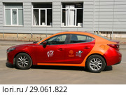 Яркий красно-оранжевый автомобиль MAZDA 3 . Московский каршеринг MАТРЁШCar (2018 год). Редакционное фото, фотограф Щеголева Ольга / Фотобанк Лори
