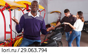 Young driver of pedicab offering touristic tour. Стоковое фото, фотограф Яков Филимонов / Фотобанк Лори
