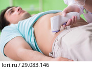 Young man visiting radiologyst for ultrasound procedure. Стоковое фото, фотограф Elnur / Фотобанк Лори