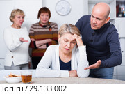 Mature female is sitting upset and man is apologizing. Стоковое фото, фотограф Яков Филимонов / Фотобанк Лори
