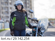 Женщина мотоциклистка стоит рядом с мотоциклом в городе. Стоковое фото, фотограф Кекяляйнен Андрей / Фотобанк Лори