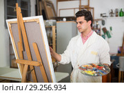 Man near easel painting on canvas. Стоковое фото, фотограф Яков Филимонов / Фотобанк Лори