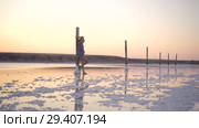 Calm girl enjoying sun, walking slowly through the water of a salt lake. Стоковое видео, видеограф Ирина Мойсеева / Фотобанк Лори