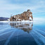 Frozen Baikal Lake. A small rocky island Cormorant Stone (Baklaniy Kamen) and blue transparent ice with cracks. Beautiful winter landscape. Стоковое фото, фотограф Виктория Катьянова / Фотобанк Лори