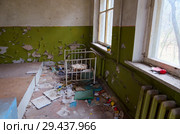Спальное помещение в заброшенном детском саде в уничтоженном селе Копачи (10-километровая зона отчуждения ЧАЭС), Украина (2018 год). Стоковое фото, фотограф Ольга Коцюба / Фотобанк Лори