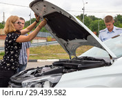 Девушка открывает капот автомобиля для проверки инспектором МРЭО ГИБДД города Воронеж (2018 год). Редакционное фото, фотограф Вячеслав Палес / Фотобанк Лори