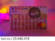 Пластиковая карта рассрочки Халва на разноцветном фоне. Редакционное фото, фотограф Владимир Пойлов / Фотобанк Лори