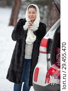 Young woman standing near suv and holding tea mug in hands at winter season. Стоковое фото, фотограф Кекяляйнен Андрей / Фотобанк Лори