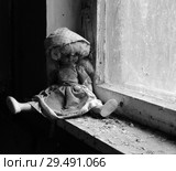 Кукла, сидящая на подоконнике в заброшенном детском саде в уничтоженном селе Копачи, зона отчуждения ЧАЭС, Украина (2018 год). Стоковое фото, фотограф Ольга Коцюба / Фотобанк Лори