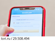 Регистрация в мобильной версии Amazon.com. Смартфон в руке (2018 год). Редакционное фото, фотограф E. O. / Фотобанк Лори
