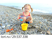 Cute happy little girl plays on the beach. Стоковое фото, фотограф ivolodina / Фотобанк Лори