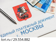 Единый платежный документ за коммунальные услуги, рублевые купюры и ручка. Стоковое фото, фотограф Игорь Низов / Фотобанк Лори
