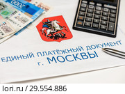 Единый платежный документ г. Москвы за коммунальные услуги, российские деньги, калькулятор и шариковая ручка. Стоковое фото, фотограф Игорь Низов / Фотобанк Лори