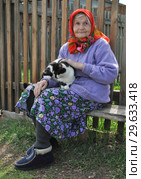 Пожилая женщина с кошкой на руках (2012 год). Редакционное фото, фотограф Пётр Писковой / Фотобанк Лори