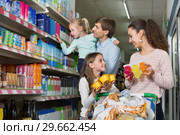 Cheerful family with two daughters purchasing yoghurts. Стоковое фото, фотограф Яков Филимонов / Фотобанк Лори