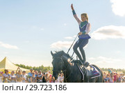 Russia, Samara, July, 2018: a Cossack girl rides a horse and performs tricks. Редакционное фото, фотограф Акиньшин Владимир / Фотобанк Лори