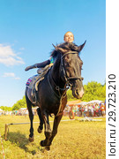 Russia, Samara, July, 2018: a Cossack girl rides a horse and performs tricks. Редакционное фото, фотограф Акиньшин Владимир / Фотобанк Лори