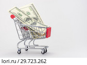 Несколько сто долларовых купюр сша лежат в продуктовой тележке. Стоковое фото, фотограф Иванов Алексей / Фотобанк Лори