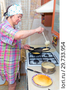 Mature woman bakes pancakes in the kitchen. Стоковое фото, фотограф Акиньшин Владимир / Фотобанк Лори