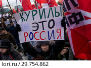Участники акции против передачи Курильских островов Японии, организованной представителями "Левого фронта" на Суворовской площади города Москвы, держат плакат с надписью "Курилы это Россия" (2019 год). Редакционное фото, фотограф Николай Винокуров / Фотобанк Лори